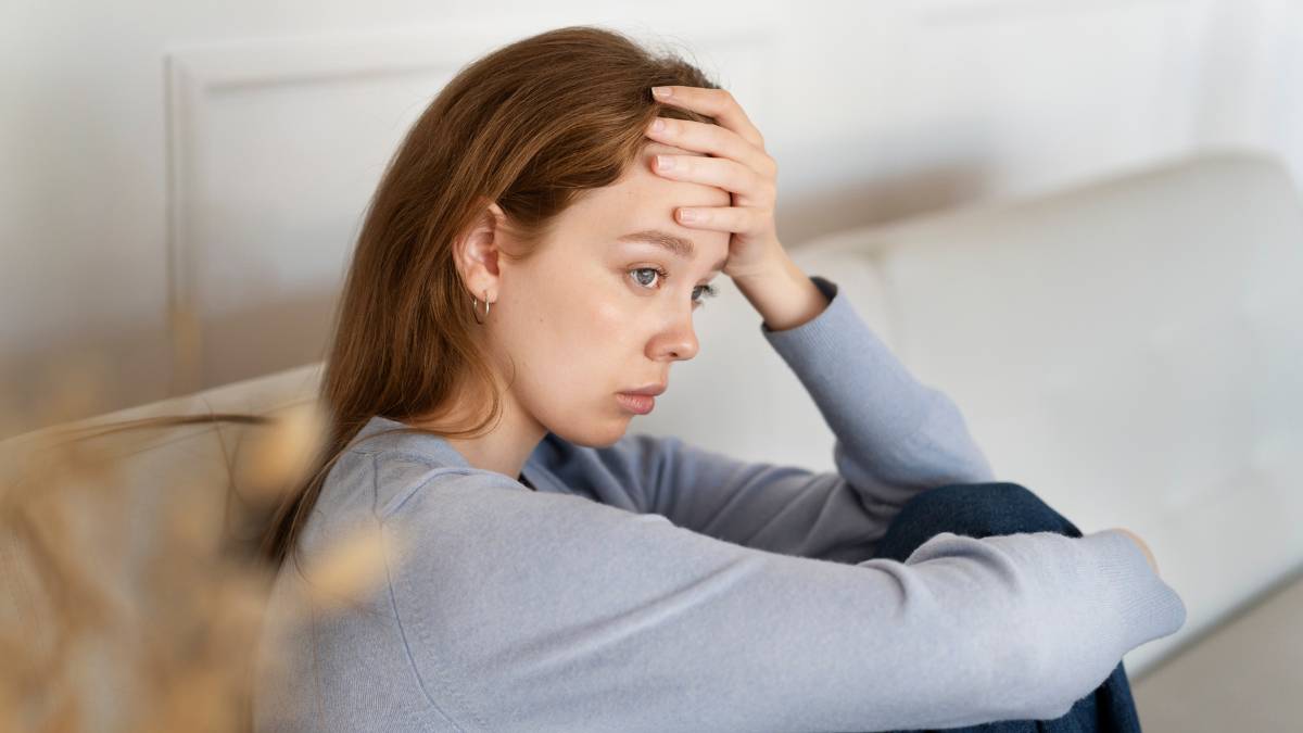 A woman struggling with Xanax addiction sitting on a sofa.